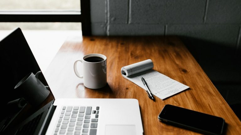 Οργανωμένο γραφείο με φορητό υπολογιστή και σημειωματάριο